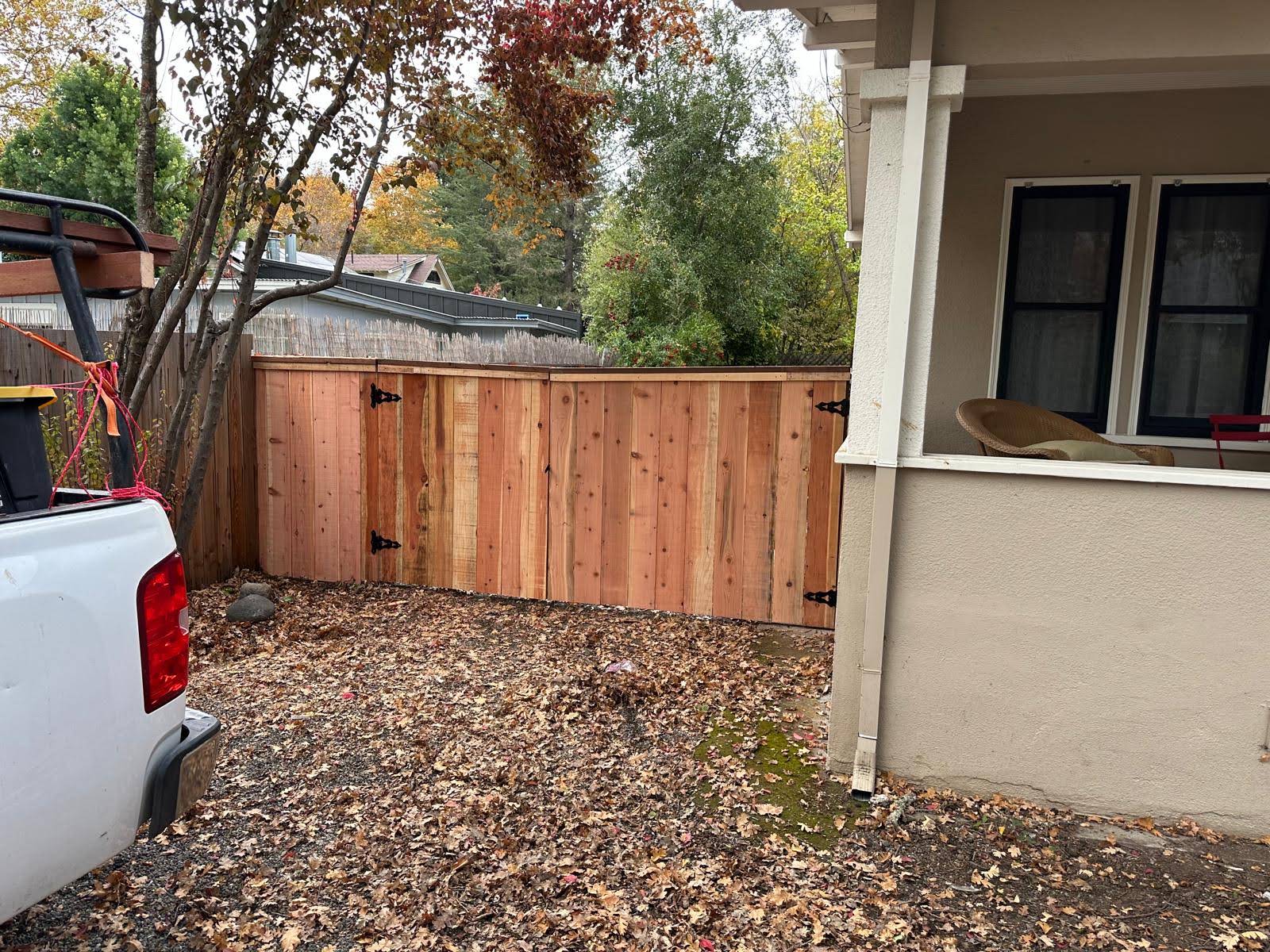 New natural wood privacy fence and gate beside a home